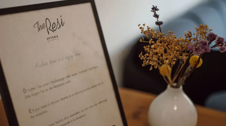 Panneau avec texte à côté d'un vase avec des fleurs sur une table