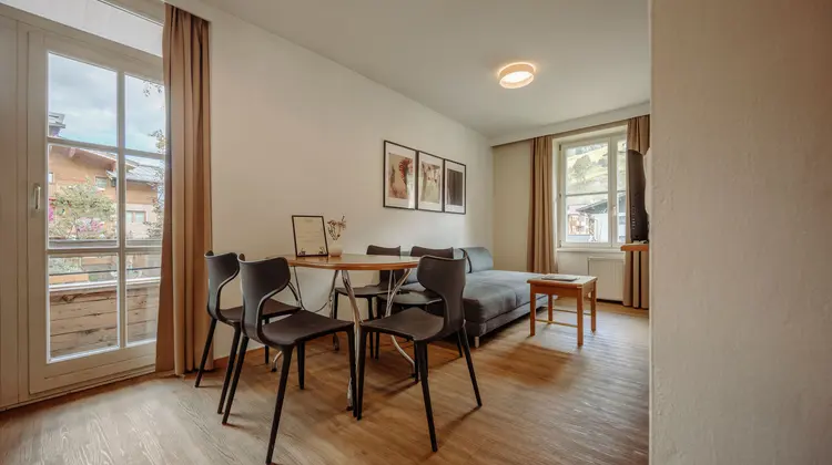 Salon avec table à manger, chaises, canapé et tableaux aux murs