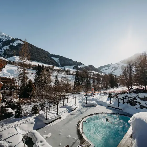 Winterlandschaft mit Pool und schneebedeckten Bergen im Hintergrund