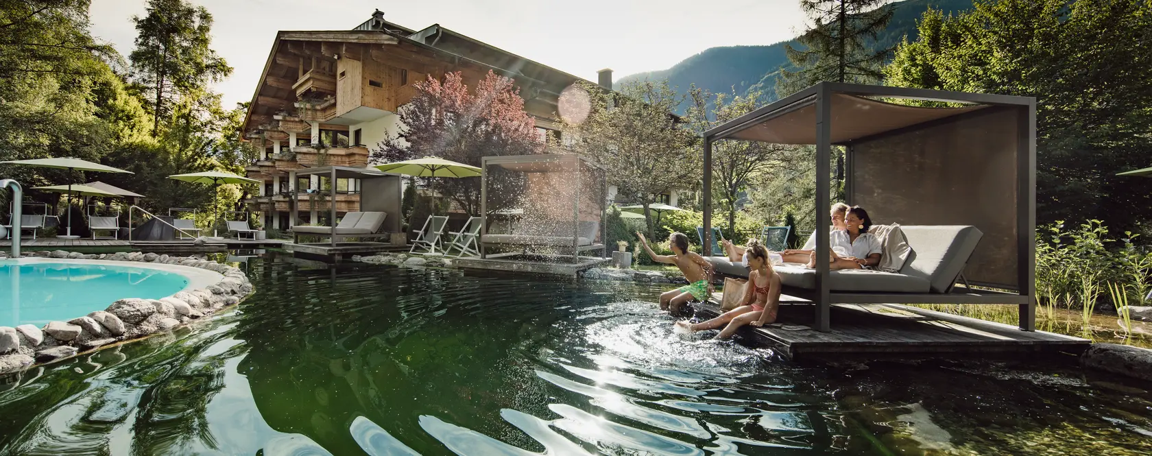 Parents with two children at the swimming pond in the garden