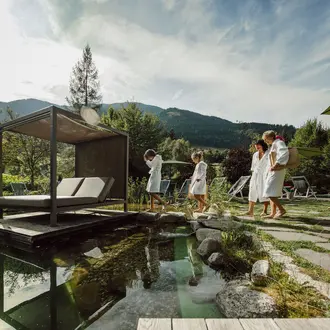 Parents with two children in bathrobes at the bathing pond