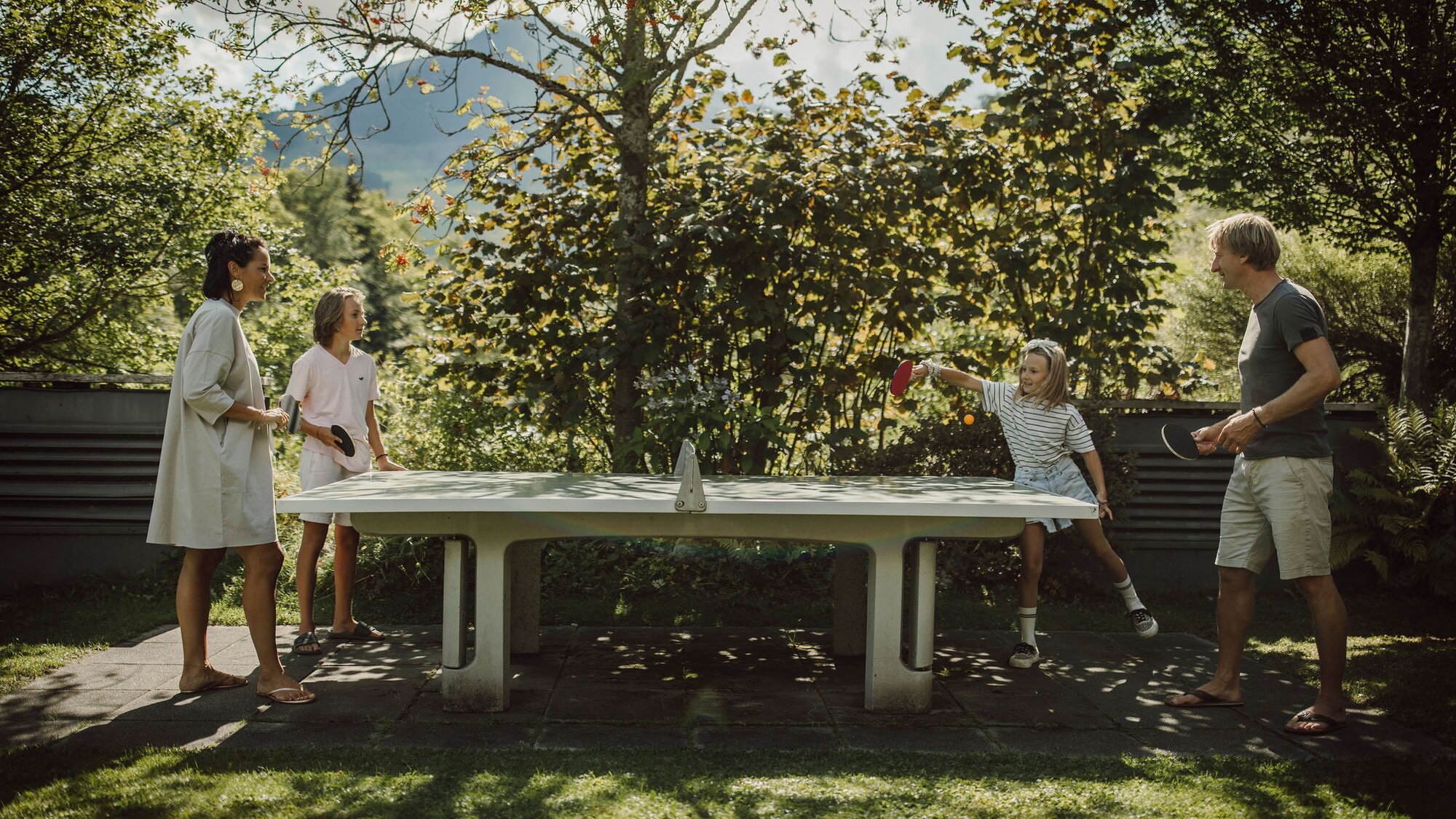 Familie spielt Tischtennis im Garten des Gartenhotel Theresia