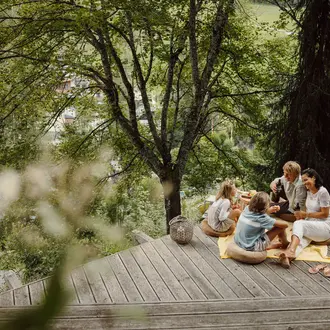 Familie macht ein Picknick auf einer Holzterrasse