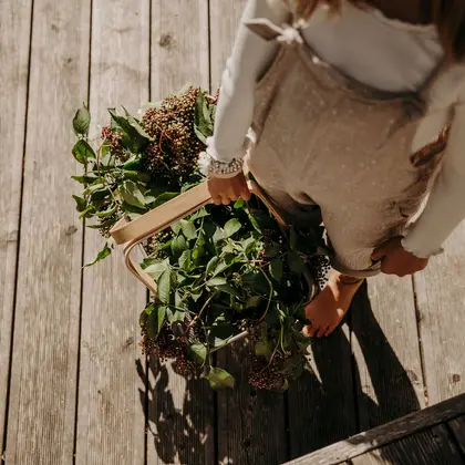 Girl with basket full of leaves and berries