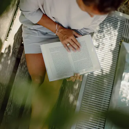 Frau ließt ein Buch im Garten